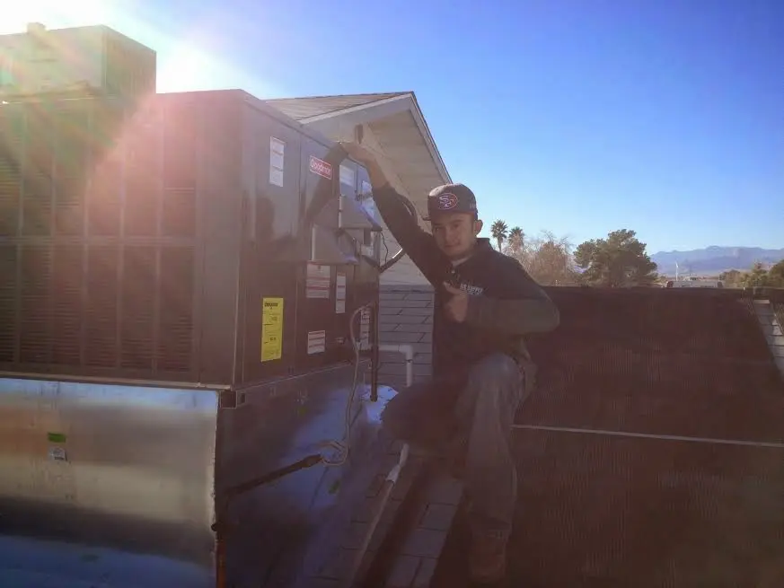 HVAC technician performing AC Tune-Up on a rooftop unit in Vincent